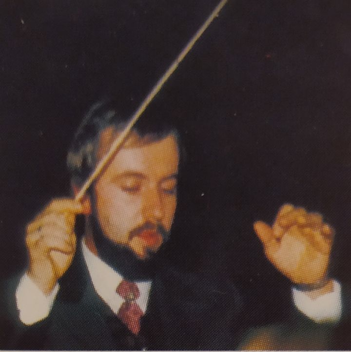 Kapellmeister Robert Habenschuss dirigiert mit Taktstock